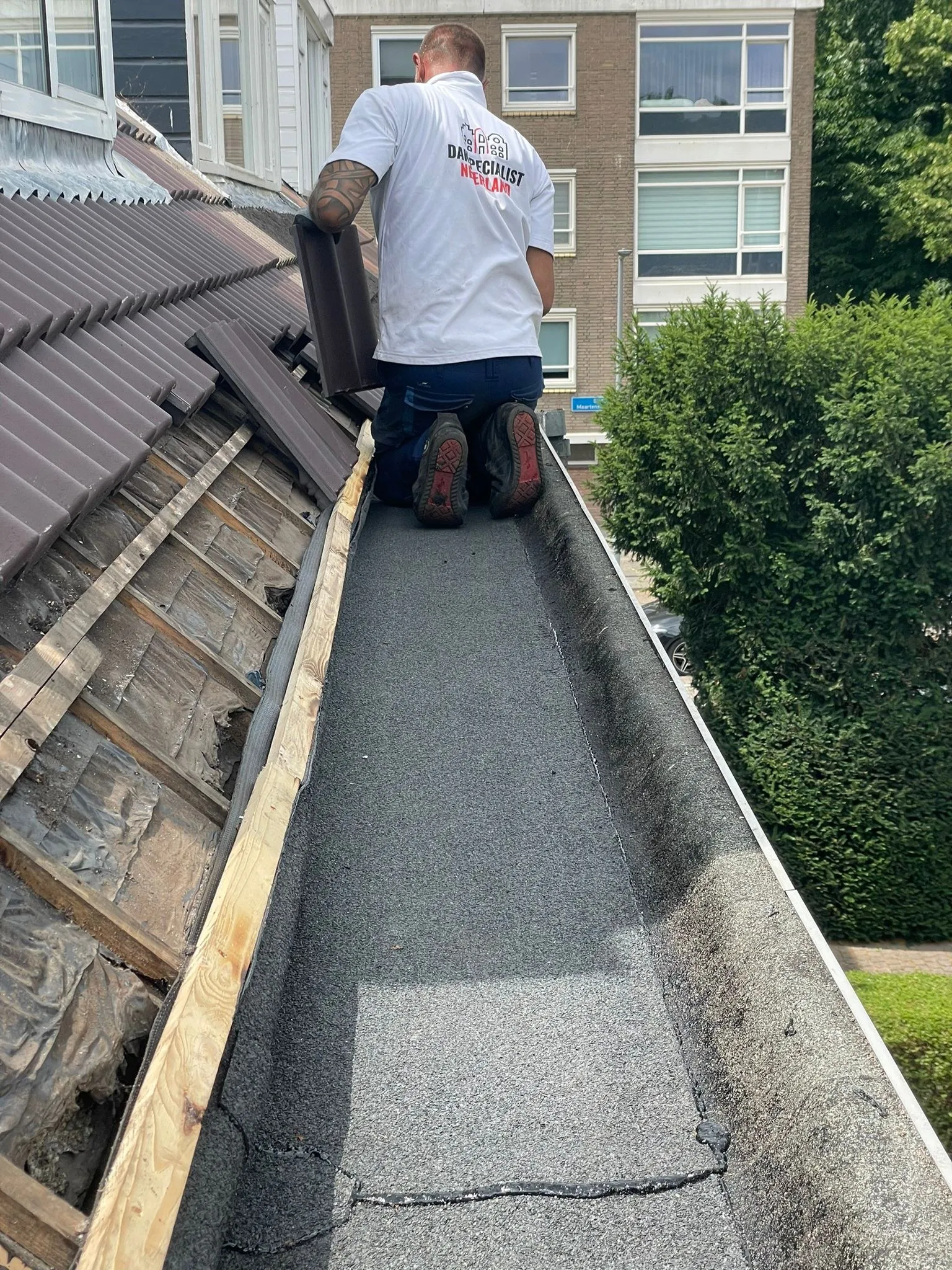 Dakdekker herstelt een bakgoot met bitumen