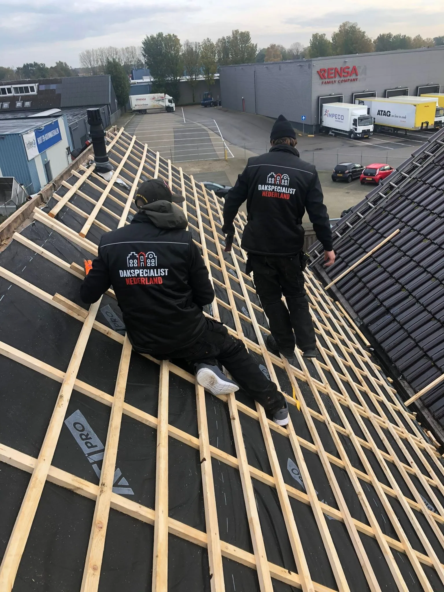 Dakdekkers leggen nieuwe panlatten tijdens een dakrenovatie