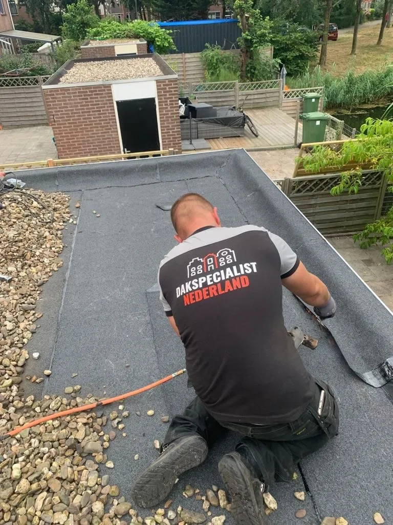 Dakdekker dicht een lekkage op een plat dak met nieuwe bitumen